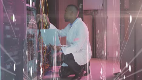 Animation-of-lights-and-lines-over-african-american-man-working-in-server-room