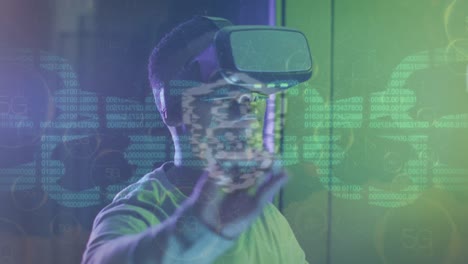 Animation-of-digital-chain-over-african-american-man-using-vr-headset-in-server-room