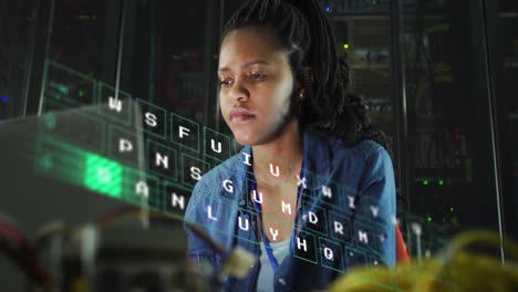 Animation-of-letters-changing-over-biracial-woman-working-on-laptop-in-server-room