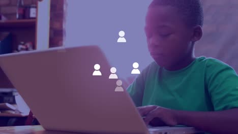 Animation-of-social-medial-icons-over-happy-african-american-boy-using-laptop-at-school