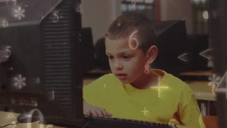 Animation-of-multiple-numbers-and-symbols-falling-over-caucasian-boy-using-computer-at-school