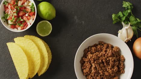 Video-Von-Tacos,-Salat,-Fleischzitrone-Und-Anderen-Zutaten-Auf-Schwarzem-Hintergrund