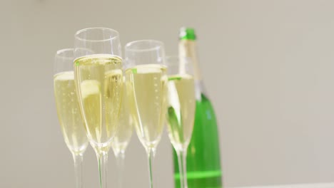 Video-of-champagne-in-glasses-and-bottle-on-beige-background