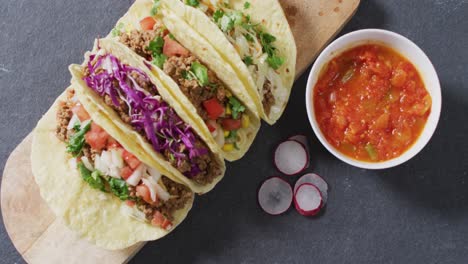 Video-Von-Frisch-Zubereiteten-Tacos,-Die-An-Bord-Auf-Grauem-Hintergrund-Liegen