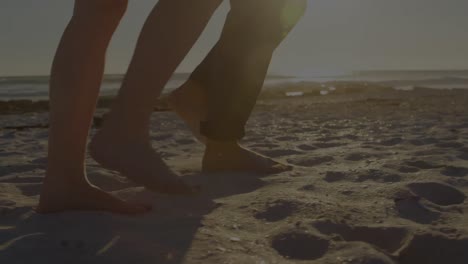 Animation-of-light-spots-over-caucasian-couple-walking-on-beach