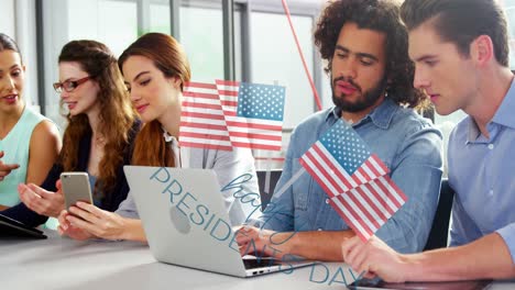 Animation-of-flags-of-usa-and-happy-presidents-day-over-diverse-businesspeople-in-office
