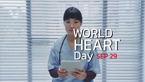 Animation-of-world-heart-day-icon-over-asian-female-doctor