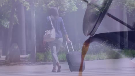 Composite-video-of-tea-pouring-out-of-kettle-against-businesswoman-with-trolley-bag-walking