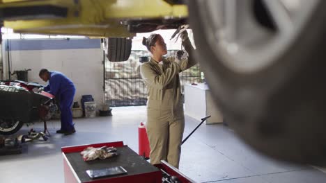 Video-of-biracial-female-car-mechanic-repairing-car