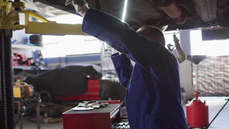 Video-of-african-american-female-car-mechanic-checking-car