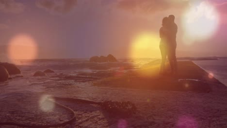 Animation-of-light-spots-over-african-american-couple-at-beach