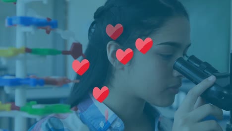 Animation-of-hearts-falling-over-biracial-schoolgirl-in-laboratory