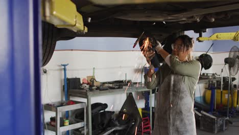 Video-of-biracial-female-car-mechanic-using-grinder