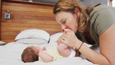 Video-Einer-Glücklichen-Kaukasischen-Mutter,-Die-Die-Füße-Ihres-Neugeborenen-Küsst