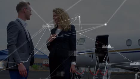 Animation-of-network-of-connections-over-caucasian-businesspeople-talking-in-front-of-plane