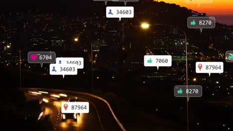 Animation-of-social-media-icons-over-aerial-view-of-cityscape-at-night