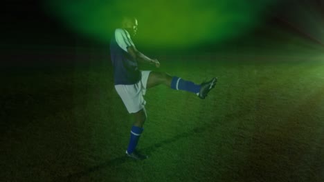 Animation-of-green-spot-of-light-against-african-american-male-soccer-player-kicking-the-ball