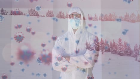Animation-of-virus-cells-and-winter-landscape-over-caucasian-doctor-wearing-face-mask