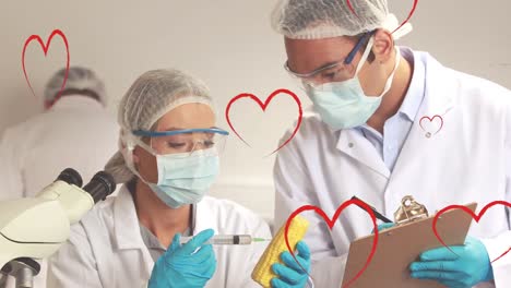 Animation-of-hearts-over-caucasian-female-and-male-lab-workers-in-safety-clothes