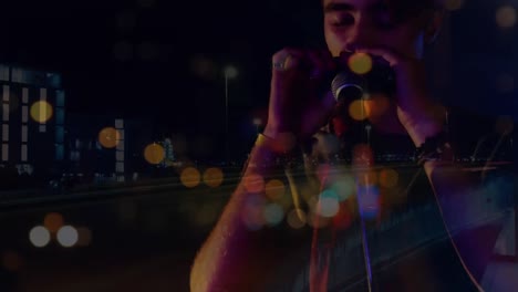 Animation-of-blurred-night-road-traffic-over-caucasian-man-playing-harmonica-on-concert