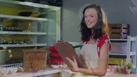 Animation-of-data-processing-over-portrait-of-smiling-caucasian-female-shopkeeper-doing-inventory