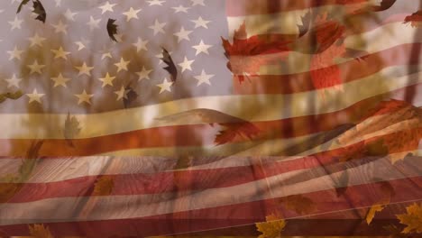 Composite-of-waving-american-flag-against-maple-leaves-falling-over-wooden-surface
