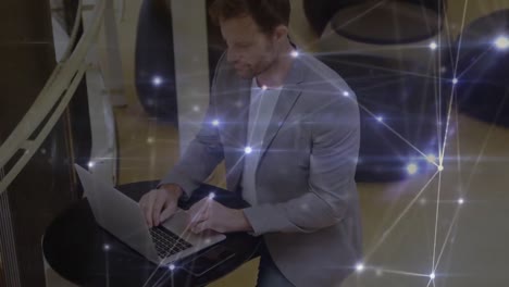 Glowing-network-of-connections-over-thoughtful-caucasian-businessman-using-a-laptop-at-office