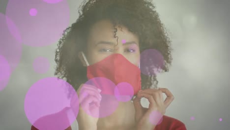 Animation-Von-Formen-über-Einer-Afroamerikanischen-Frau-Mit-Gesichtsmaske