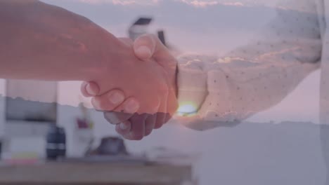 Animation-of-diverse-business-people-shaking-hands-over-landscape