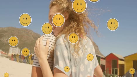 Animation-Von-Emoji-Symbolen-über-Einem-Glücklichen-Kaukasischen-Paar,-Das-Sich-Am-Strand-Umarmt