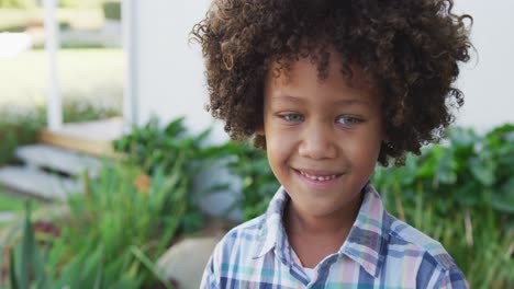 Video-of-happy-smiling-biracial-boy-outside-of-house