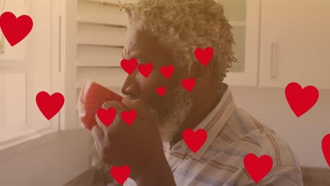 Animation-of-hearts-over-african-american-man-drinking-coffee