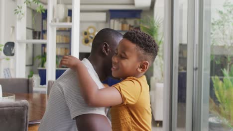 Video-Eines-Glücklichen-Afroamerikanischen-Vaters-Und-Sohnes,-Der-Sich-Zu-Hause-Umarmt