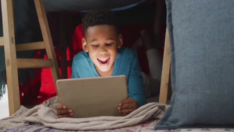 Video-Eines-Glücklichen-Afroamerikanischen-Jungen,-Der-Zu-Hause-Ein-Tablet-Benutzt