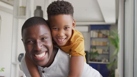 Video-of-happy-african-american-father-and-son-hugging-at-home