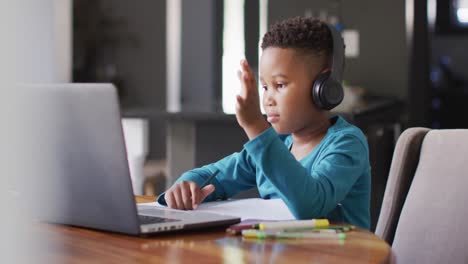 Video-Eines-Afroamerikanischen-Jungen-Mit-Kopfhörern,-Der-Mit-Einem-Laptop-Lernt