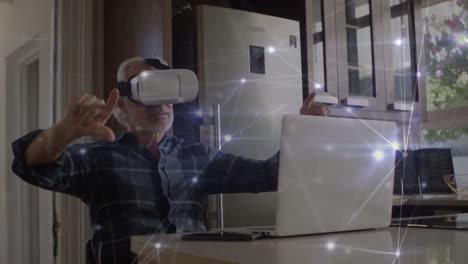 Animation-of-glowing-network-of-connections-over-caucasian-senior-man-wearing-vr-headset-at-home