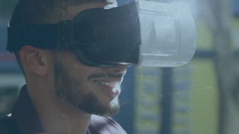 Animation-of-network-of-connections-over-close-up-of-biracial-man-wearing-vr-headset-at-office