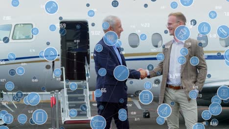 Animation-of-network-of-digital-icons-over-two-caucasian-businessmen-shaking-hands-at-the-airport