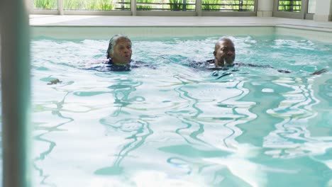 Video-Eines-Glücklichen-älteren-Afroamerikanischen-Paares,-Das-Im-Pool-Schwimmt