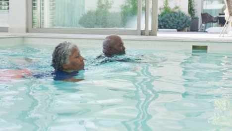 Video-Eines-Glücklichen-Afroamerikanischen-Paares,-Das-Im-Pool-Schwimmt