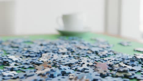 Video-of-puzzles-and-cups-of-coffee-on-green-table