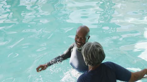 Video-Eines-Glücklichen-älteren-Afroamerikanischen-Paares,-Das-Im-Pool-Schwimmt