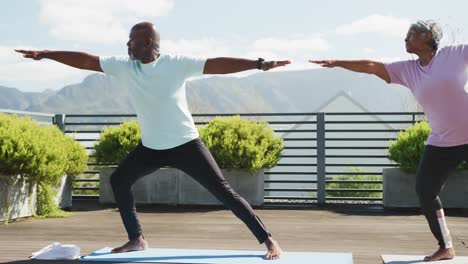 Video-of-happy-african-american-couple-exercise-on-the-terrace