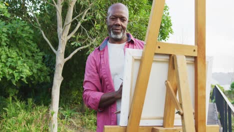 Video-of-happy-senior-american-african-men-painting-in-the-garden