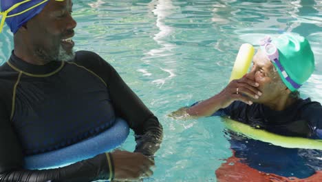 Video-Eines-Glücklichen-älteren-Amerikanischen-Afrikanischen-Paares,-Das-Im-Pool-Trainiert