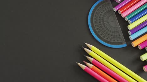 Vídeo-De-Composición-Con-Crayones-De-Colores-Y-Herramientas-Escolares-Sobre-Una-Superficie-Gris-Con-Espacio-Para-Copiar