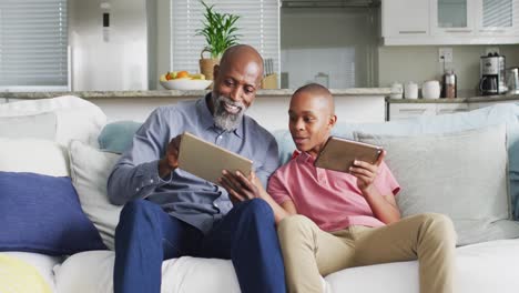 Video-Eines-Glücklichen-Afroamerikanischen-Vaters-Und-Sohnes,-Die-Gemeinsam-Tablets-Verwenden