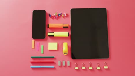 Video-Der-Zusammenstellung-Von-Schulsachen,-Smartphone-Und-Tablet-Mit-Kopierraum-Auf-Rosa-Oberfläche