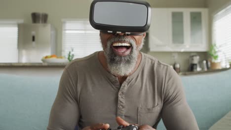 Video-Eines-Glücklichen-Afroamerikanischen-Mannes,-Der-Ein-VR-Headset-Verwendet-Und-Zu-Hause-Videospiele-Spielt